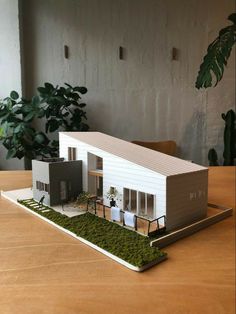 a model of a house sitting on top of a wooden table