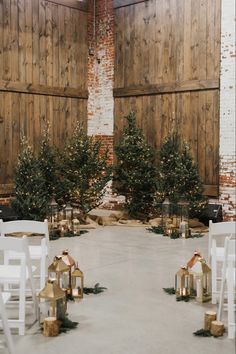 an indoor ceremony with white chairs and christmas trees