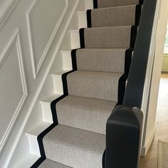 there is a black and white carpeted stair case at the bottom of this set of stairs