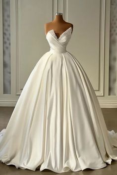 a wedding dress on display in front of a white wall