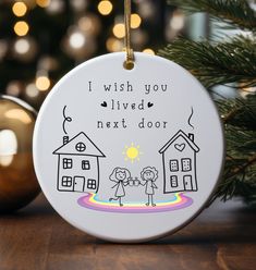 a ceramic ornament that says i wish you lived next door with two people holding hands