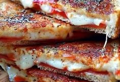 grilled cheese sandwiches stacked on top of each other with sauce and seasoning sprinkles