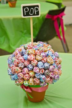 a pot filled with lots of candy sitting on top of a green cloth covered table