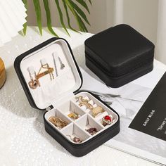 an open black case with jewelry inside on a table