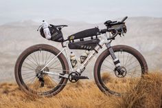 a bike parked on top of a dry grass field