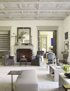 a living room filled with furniture and a fire place in the middle of a room