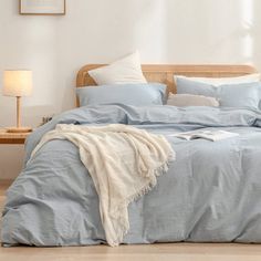 a bed with blue sheets and pillows in a room