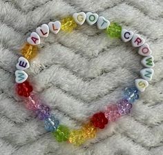 a beaded bracelet that says love is spelled with letters and beads on a white blanket