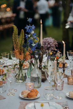 the table is set with flowers and candles