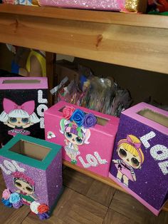 three boxes with littlest pet shop pictures on them, one is pink and the other is purple