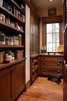 a kitchen with lots of wooden cabinets and drawers