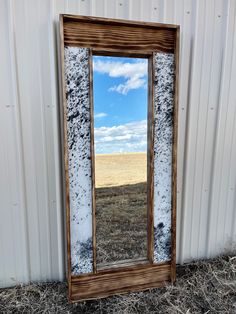 a large mirror sitting on top of a dry grass field