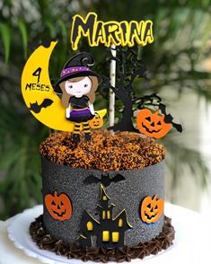 there is a cake decorated to look like a witch on the moon and pumpkins