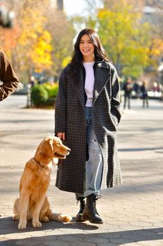 a woman is walking her dog down the street