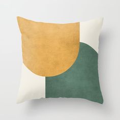 a green and yellow pillow sitting on top of a white wall