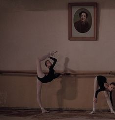 two ballerinas in black leotards and white tights are standing on one leg