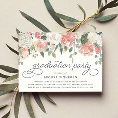 an elegant floral graduation party card with greenery and flowers on the front is shown