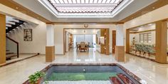 an indoor swimming pool in the middle of a room with stairs leading up to it