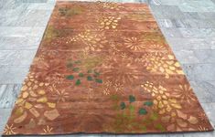 a brown and green rug sitting on top of a stone floor next to a sidewalk