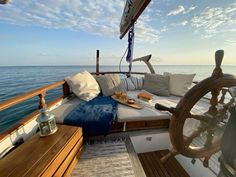 the sun shines on the deck of a boat with pillows and other items sitting on it