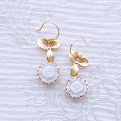 Inspired by nature, these mini flower cabochons and leaves create a pure, feminine and pretty look. They tell a romantic story about moonlight and roses. They pair perfectly from a bridesmaid gown or a cocktail dress to your smart clothes or your T-shirt and jeans. Earrings are made of porcelain flower cabochons; gold-pated brass base; gold-plated silver ear hooks. Material: Handmade porcelain moonlight rose cabochons; Gold-plated brass bases; Gold-plated brass leaves; Gold-plated silver ear hoo Elegant White Round Flower Earrings, Elegant Petal-shaped Jewelry With 3d Flowers, Elegant Petal Shaped Jewelry With 3d Flowers, Elegant White Floral Earrings, Elegant Petal-shaped 3d Flower Jewelry, Delicate Birth Flower Earrings, Delicate Pearl White Flower Earrings, Elegant Pearl White Jewelry With 3d Flowers, Delicate Petal-shaped Jewelry With Matching Earrings