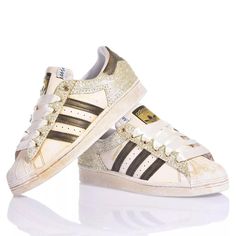 Adidas Superstar Bright Gold is the custom delicate and bold women's sneaker. Completely washed in gold with a gold and white glitter back and eyelets and cream-colored satin laces. &nbsp;Adidas Superstar Bright Gold will also come with its original white laces. Gold Low-top Sporty Custom Sneakers, Sporty Gold Low-top Custom Sneakers, Gold Custom Sneakers For Streetwear With Round Toe, Gold Custom Sneakers For Streetwear, Gold High-top Sneakers With Gum Sole, Gold High-top Custom Sneakers With Boost Midsole, Gold Sneakers With Gum Sole And Round Toe, Gold Low-top Sneakers With Laces, Gold Lace-up Sneakers