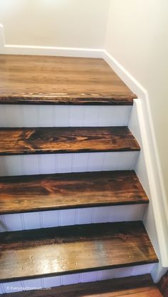 some wooden stairs in a house with white walls