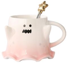 a white ceramic mug with a gold star on the top and a face drawn on it