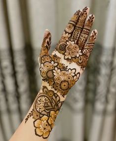 a woman's hand with henna tattoos on it