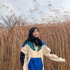 a woman standing in front of tall grass