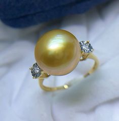 Stunning South Sea Golden Pearl Ring, 11.7mm, Bright Rich Gold Color, Deep Tone with Green overtone, Very High Luster, Absolutely Stunning.   Solid 18k Yellow Gold with Diamonds, Well made and Comfortable to wear. US Size 7.5. Elegant and stunning. Something you can wear forever.  Stunning and Elegant    Lustrous beauty  Pearl ★ Genuine South Sea Golden Pearl ★ Size: 11.7mm ★ Shape: Near Perfect Round ★ Color: Natural Untreated, Bright Rich Sunny Gold, Deep tone with Green overtone, Stunning ★ L Fine Jewelry Yellow Round Diamond Ring, Yellow Gold Fine Jewelry Rings With High Luster, Fine Jewelry Yellow Gold Rings, Aaa Quality Fine Jewelry Yellow Gold Rings, Yellow Diamond Round Ring For Anniversary, Yellow Diamond Round Anniversary Ring, Fine Jewelry Yellow Gold Pearl Ring With High Luster, Yellow Gold Pearl Ring With High Luster, Fine Jewelry Diamond Ring With High Luster