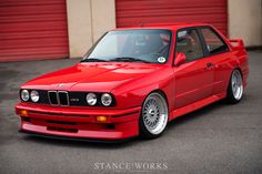 a red car parked in front of a garage