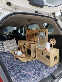 the back end of a car filled with wooden crates and boxes on top of a bed