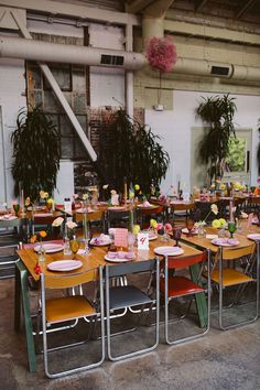 the tables are set with colorful plates and flowers