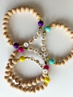 This simple, bright Mama bracelet is a wonderful gift for any mama, whether elderly, adoptive, foster, or an expecting mama! The colors include natural blonde wood, gold and either pink, purple, aqua or yellow. Give this bracelet to any mother figure in your life, and remind them that they play such an important role. 💖 Bracelets are made to comfortably fit an average adult wrist size of 6.75 inches. FREE SHIPPING! Adjustable Stretch Bracelet With 8mm Beads For Birthday, Friendship Bracelets For Mother's Day With Round Beads, Adjustable 8mm Beads Friendship Bracelets For Birthday, Hand-strung Round Beads Name Bracelet For Friendship, Mother's Day Spiritual Adjustable Friendship Bracelets, Spiritual Adjustable Friendship Bracelets For Mother's Day, Spiritual Beaded Bracelets For Friendship On Mother's Day, Everyday Personalized Bohemian Bracelets, Mother's Day Spiritual Friendship Bracelets