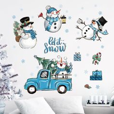 a wall with snowmen and christmas decorations on it, including a blue truck in the foreground