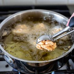 a person is stirring some food in a pot on the stove with a ladle