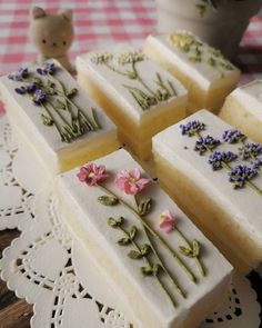 four pieces of cake sitting on top of a doily next to a potted plant