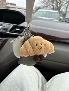 a teddy bear keychain hanging from the inside of a car