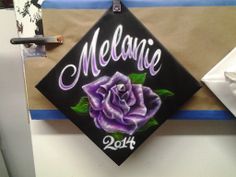 a graduation cap with a purple rose painted on it