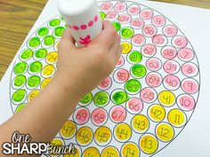 a child's hand holding a cup over a number puzzle