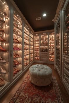 a walk in closet with lots of shoes on the shelves and lights hanging from the ceiling