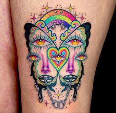 a woman's thigh with colorful tattoos on it