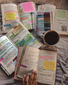 an open book on a bed next to a cup of coffee and crayons