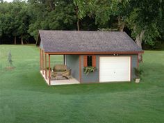 a small shed with a patio in the grass next to it and trees on the other side