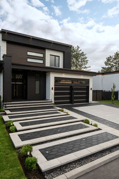 a modern house with steps leading up to the front door and garage area on either side