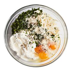 an image of eggs and cheese on a plate with parsley sprinkled around it