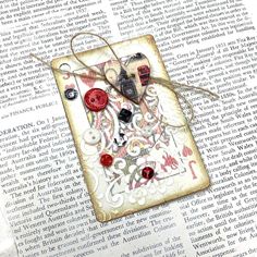 a book with some buttons on it and an old fashioned tag attached to the page