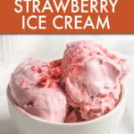 a bowl filled with pink ice cream on top of a white table next to an orange sign