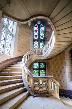 a spiral staircase with stained glass windows in the background